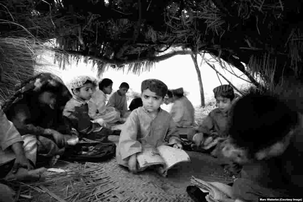 A child sits inside a makeshift school building built by Baloch refugees who fled the violence that engulfed their remote rural villages.