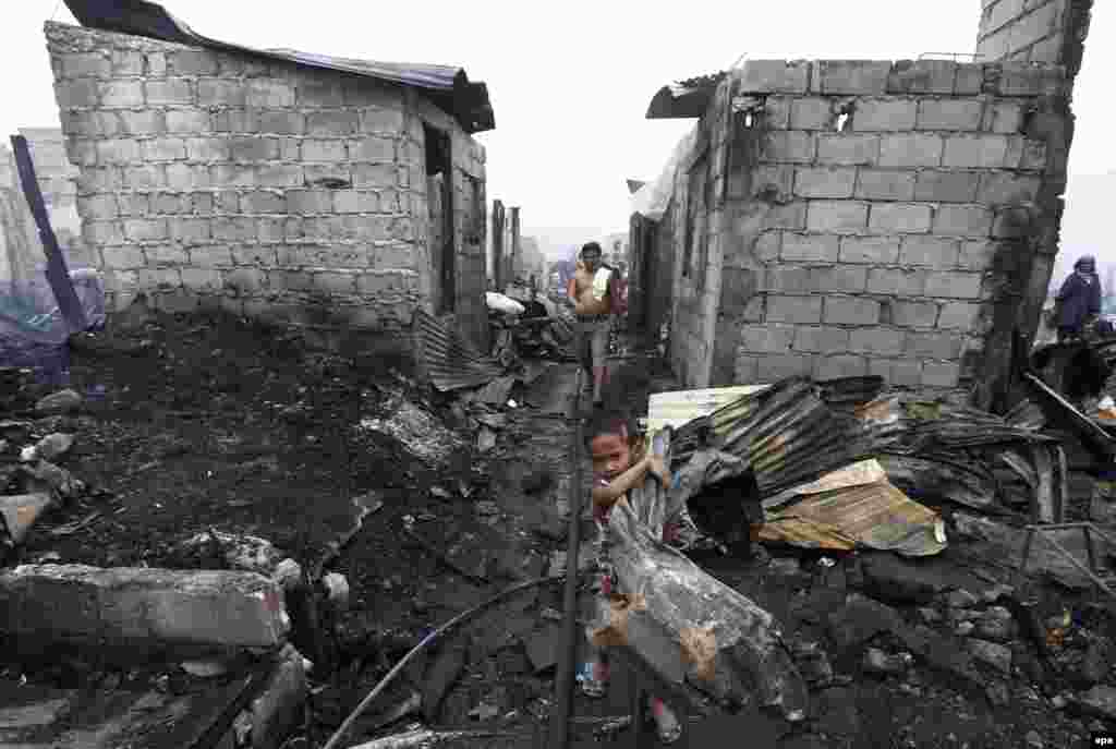 A Filipino child carries scrap metal from burned homes after a pre-dawn fire in Navotas City, north of Manila. (epa)