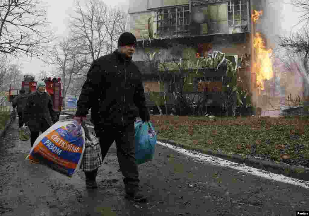 Місцеві мешканці виносять речі з палаючого після обстрілу будинку на околиці Донецька, 9 лютого 2015 року