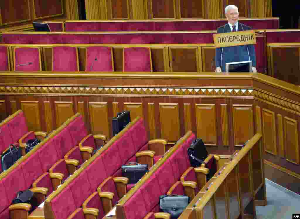 A cardboard cut-out of Ukrainian Prime Minister Mykola Azarov with a placard around its neck reading &quot;Predecessor&quot; stands in parliament in Kyiv after being set up by the parliamentary opposition as deputies tried to block the speaker&#39;s platform. The deputies were trying to prevent an initiative to deprive Serhiy Vlasenko, the lawyer of jailed former Prime Minister Yulia Tymoshenko, of his deputative powers and status. (AFP/Sergei Supinsky)