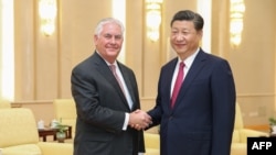 US Secretary of State Rex Tillerson (L) shakes hands with Chinese President Xi Jinping (R) before their meeting at the Great Hall of the People in Beijing on September 30, 2017. / AFP PHOTO / POOL / Lintao Zhang