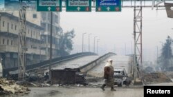 Syria -- A woman crosses the Al-Haj highway, which is closed because of sniper fire by pro-government forces, in Aleppo, January 20, 2015