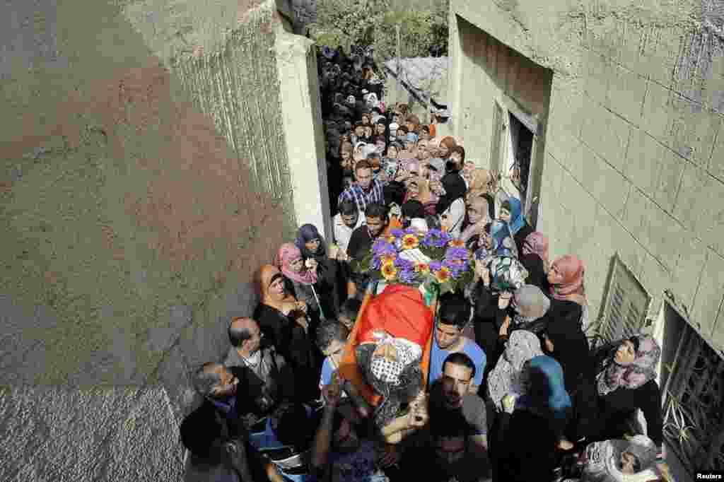 Mourners carry the body of Palestinian boy who was killed by Israeli troops at his funeral in the village of Beit Laqiya near the West Bank city of Ramallah. (Reuters/Ammar Awad)