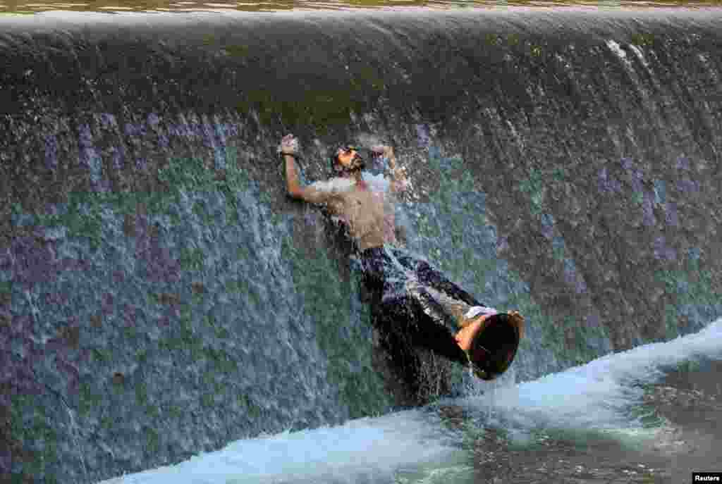 A man cools off from the heat in a stream on a hot summer day on the outskirts of Islamabad, Pakistan. (Reuters/Faisal Mahmood)