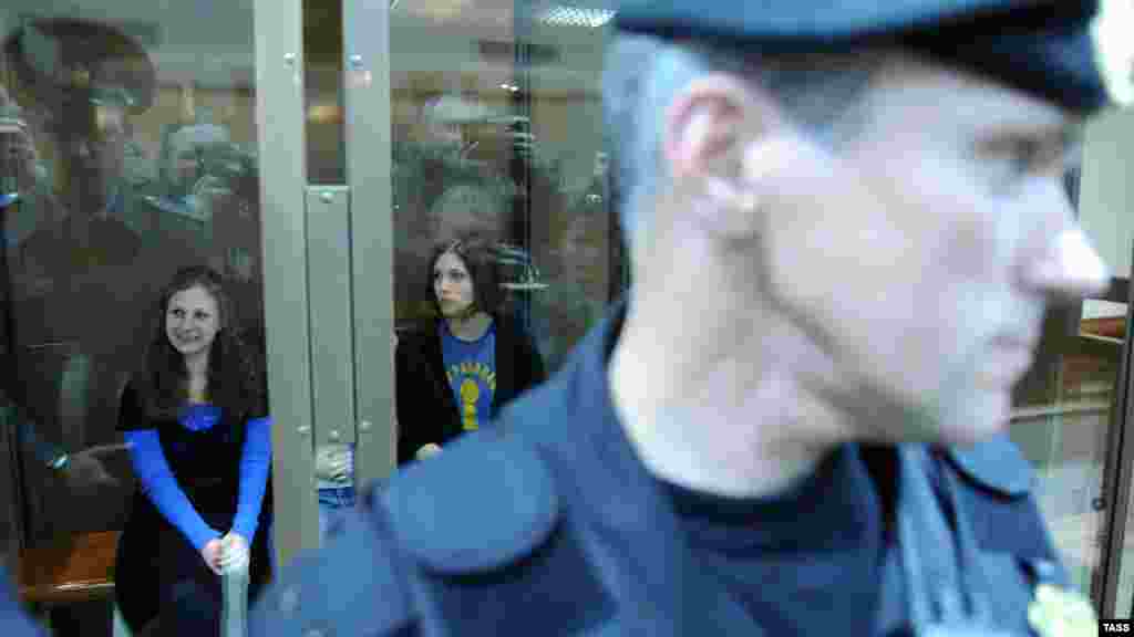 Pussy Riot members Maria Alyokhina (left) and Nadezhda Tolokonnikova sit in a glass-walled cage before a court hearing in Moscow on October 1.
