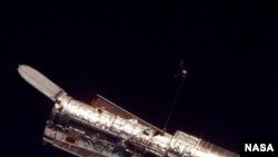 Космический телескоп Hubble. Таким увидели его астронавты шаттла Discovery. Именно снимки, выполненные с помощью Hubble, позволили построить 3D-карту темной материи.