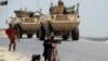 Afghan children pass security forces as they leave a village during an operation against IS militants in Nangarhar Province in May, where the U.S. military denied causing civilian casualties in a recent strike.