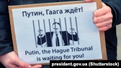 «Putin, Gaaga mahkemesi seni bekley!» yazuvlı şiar Rusiyeniñ Ukrayına istilâsına qarşı narazılıq aktsiyasında. Amsterdam, Felemenk, 2022 senesi martnıñ 6-sı