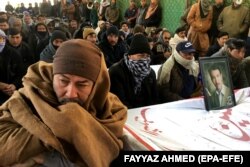 Members of the Shi'ite Hazara community in Quetta gather on January 8 around the coffins of coal miners who were killed in Balochistan by armed militants.