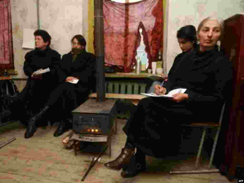 Election observers warm themselves around a stove in a polling station in the village of Tokhliauri, about 60 kilometers from Tbilisi. In addition to domestic observers, the OSCE sent more than 300 monitors to monitor the vote.
