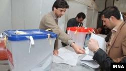 Workers begin processing votes at an election center in Tehran. 