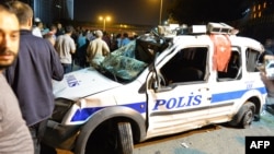 Бүлік шыққан түні қираған полиция көлігі жанында жүрген адамдар. Анкара, 16 шілде 2016 жыл.