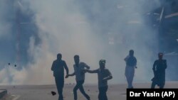 Kashmiris face Indian policemen during a protest in Srinagar, Indian-controlled Kashmir, on May 25, 2018. 
