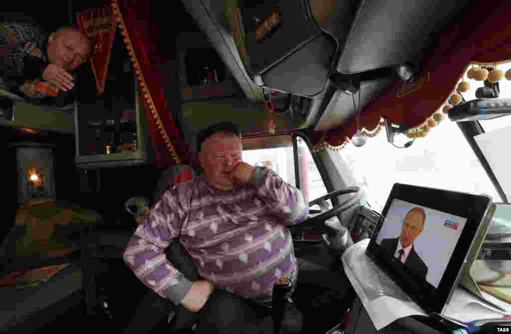 Truck drivers watch Russian President Vladimir Putin&#39;s annual state-of-the-nation address in Ivanovo on December 3. (TASS/Vladimir Smirnov)