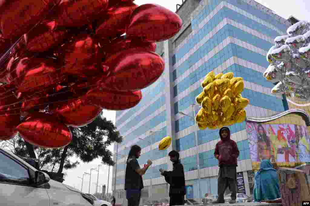 Vendors sell heart-shaped balloons on a street on Valentine&#39;s Day in Islamabad on February 14.
