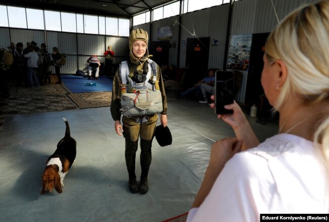 Një studente në shkollën e kadetëve Yermolov në Rusi, del në fotografi para se të ngjitet në bordin e aeroplanit për të marrë pjesë në një ushtrim për hedhje me parashutë. (Reuters/Eduard Korniyenko)