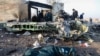 People stand near the wreckage after a Ukrainian plane carrying 176 passengers was shot down by the Revolutionary Guard near Imam Khomeini Airport in Tehran on January 8, 2020. 