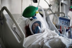 A COVID-19 patient wearing a snorkel mask fitted to a ventilator in a hospital near Paris on April 1, 2020.