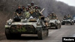 Members of the Ukrainian armed forces ride armored personnel carriers as they pull back from Debaltseve region, near Artemivsk, on February 26.