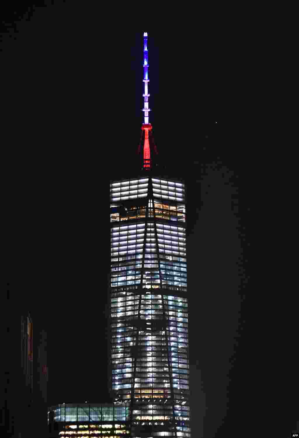 Red, white, and blue colors at the top of the tower of One World Trade Center in New York.