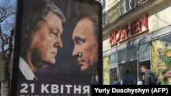 Ukraynada Poroshenko (solda) və Putinin portretləri olan seçki plakatı