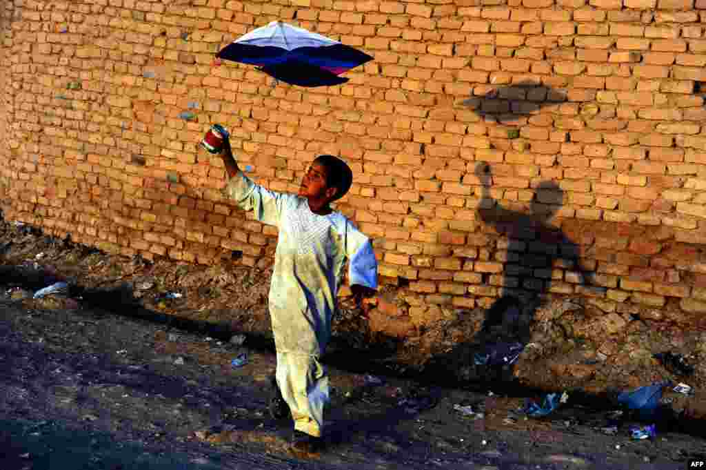 An Afghan child plays with a kite on the outskirts of Herat on October 20. (AFP/Aref Karimi)