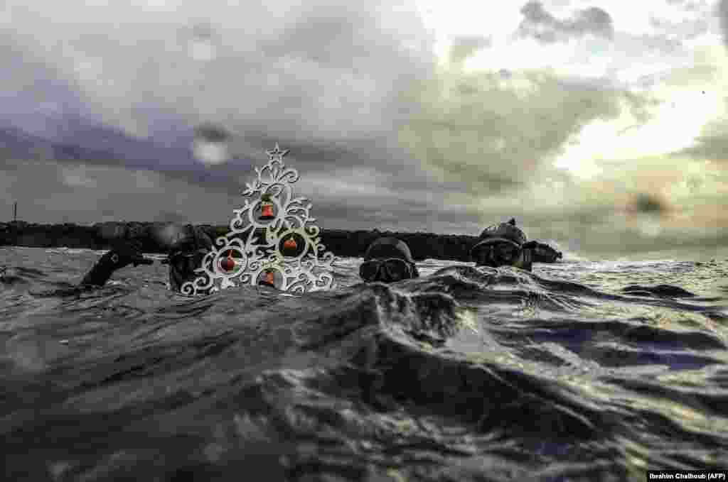 Free divers pose with a Christmas tree near the surface before diving to place it on the seafloor off the coast of the northern Lebanese port city of Tripoli. (AFP/Ibrahim Chalhoub)​