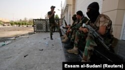 Iraqi security forces stand guard near government buildings in Basra on September 5.