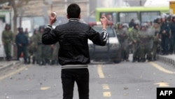 An Iranian opposition protester faces security forces during clashes in Tehran in December 2009, following the reelection of Mahmud Ahmadinejad as president.