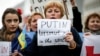 Жена държи в ръце надпис "Путин - терорист № 1 в света" по време на протестен митинг срещу анексията на Крим пред централата на ЕС в Брюксел, 17 март 2014 г.