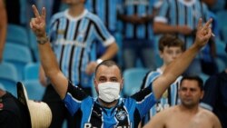 Болельщик в защитной маске на футбольном матче в Бразилии. Иллюстративное фото.
