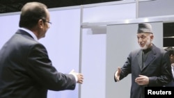 U.S. -- French President Francois Hollande (L) greets his Afghan counterpart Hamid Karzai at the NATO summit at McCormick Place in Chicago, 20May2012