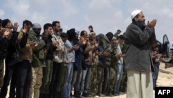 Libyan rebels pray at an area where they are engaged in street battles with forces loyal to Qaddafi near Brega on April 3.