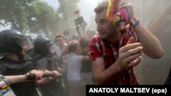 Russian police push a gay-rights activist away from the scene of a gay-pride event to prevent clashes with antigay protesters in St. Petersburg in June 2013.