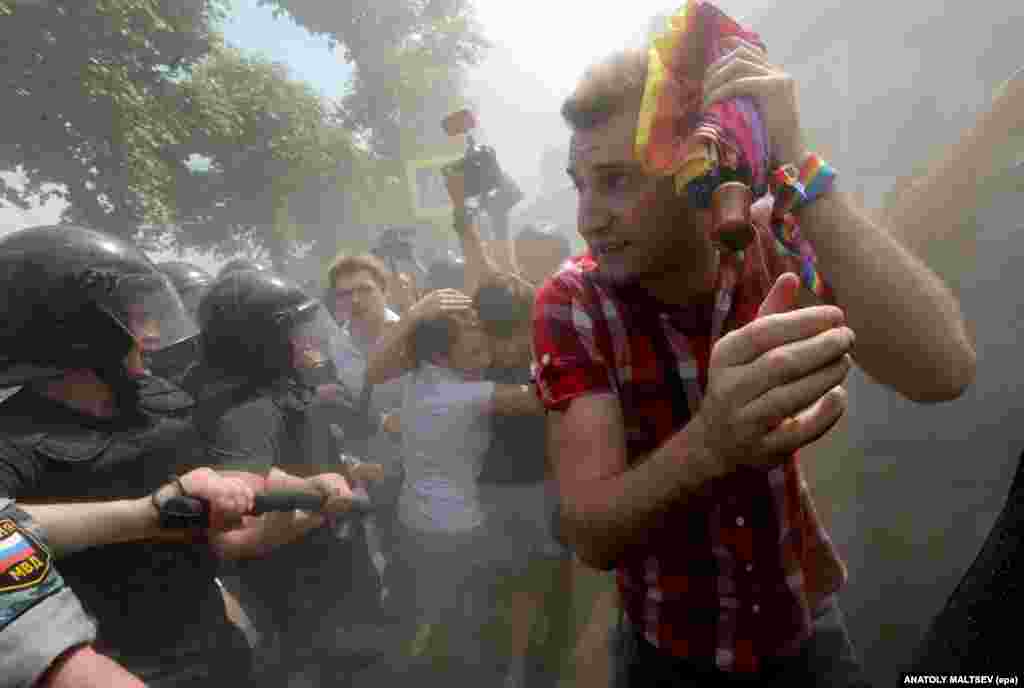 Rights activists run a gauntlet of riot police as debris rains down during a gay pride event in St. Petersburg in 2013.&nbsp; &nbsp;