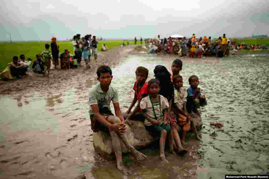 Rohingya refugees sit as they are temporarily held by the Border Guard Bangladesh in an open area after crossing the border in Teknaf. (Reuters/Mohammad Ponir Hossain)