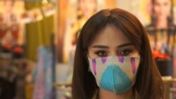 A woman wears a face mask made from traditional Tajik fabric by local designer Nafisa Imronova in response to soaring demand in the Central Asian country for facial coverings.