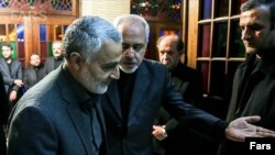 Quds Force commander Qasem Soleimani (left) is welcomed by Foreign Minister Mohammad Javad Zarif to the funeral of Zarif's mother in 2013.