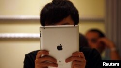 iPad қарап отырған қытайлық. Пекин, 6 маусым 2012 жыл.