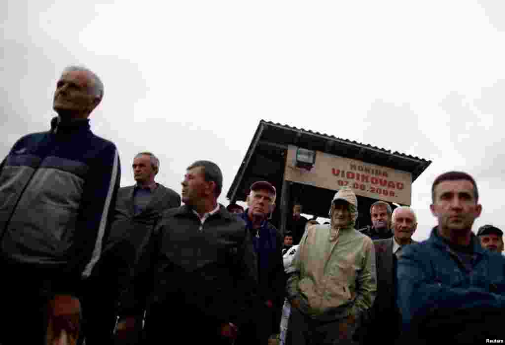 People watch a bullfight in front of the commentary cabin.