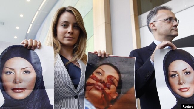 Belgium -- Member of the EU Parliament Barbara Matera (L) displays pictures of Iranian woman Neda Agha-Soltan, killed last year during a post election anti-government protest in Tehran, as she waits for the arrival of Iranian Foreign Minister, Brussles, 0