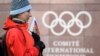 SWITZERLAND -- A supporter stands with a Russian flag in front of the logo of the International Olympic Committee (IOC) at the headquarters on December 5, 2017 in Pully near Lausanne.