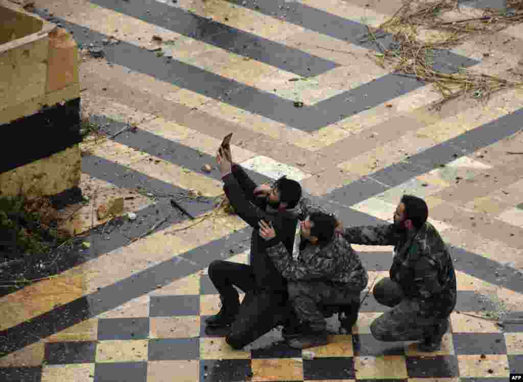 Syrian pro-government forces take a selfie in the courtyard of the ancient Umayyad mosque in the old city of Aleppo on December 13. After weeks of heavy fighting, regime forces were poised to take full control of Aleppo, dealing the biggest blow to Syria's rebellion in more than five years of civil war. (AFP/George Ourfalian)