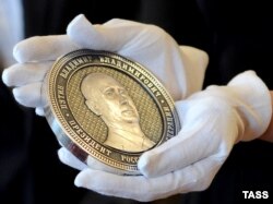 Monedă comemorativă a anexării Crimeei cu figura președintelui Rusiei