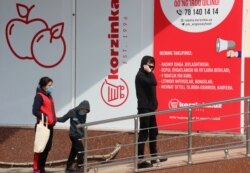 Люди в защитных масках стоят в очереди у входа в продуктовый магазин. Ташкент, 9 апреля 2020 года.