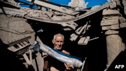 Чоловік біля зруйнованого будинку на Донбасі, архівне фото 