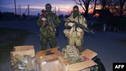 Ukrainian forces pose next to boxes of equipment donated to them by pro-Kyiv activists from across the country who have been collecting money to buy much-needed supplies for the country's cash-strapped army.