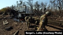 Ukrainian soldiers sort through the wreckage of an artillery convoy destroyed earlier by Russian firepower in September 2014.