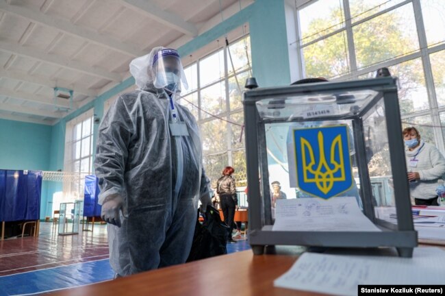Një anëtar i komisionit zgjedhor për zgjedhjet lokale në Ukrainë, ka veshur veshje mbrojtëse kundër koronavirusit. Slovyansk, 25 tetor. (Reuters/Stanislav Kozliuk)