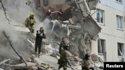 People remove debris following the collapse of an apartment building as a result of what local authorities called a Ukrainian missile strike on the Russian city of Belgorod on May 12. 